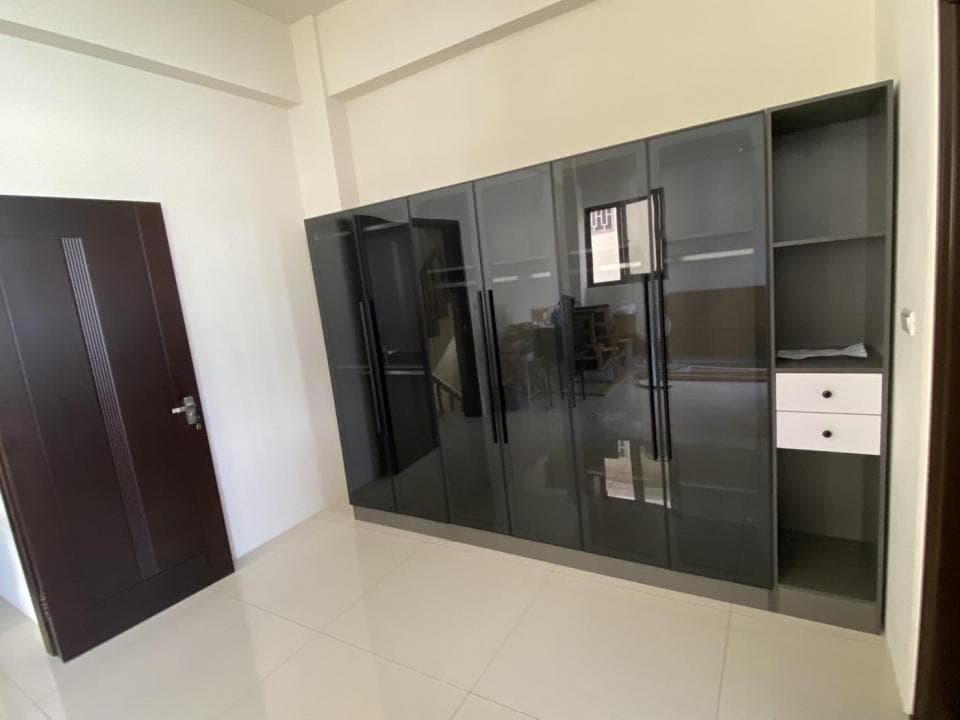 這張照片是一間房子的房間,房間裡有一面牆壁上裝了一個大型的玻璃櫃,櫃子裡有許多層架,可以擺放各種物品。