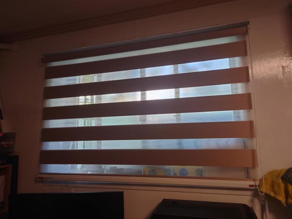 1) 照片顯示一扇窗戶,窗戶上裝有百葉窗,百葉窗是半開的,透著陽光