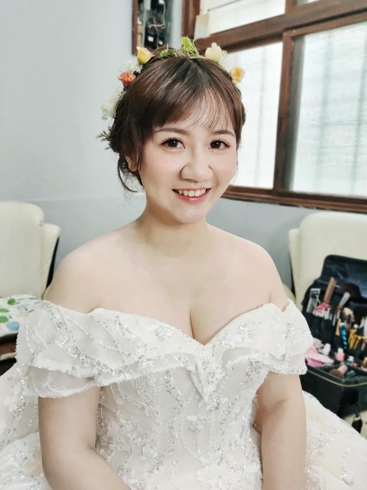 這張照片是一位美麗的新娘,她穿著一件精緻的婚紗,頭上戴著花環,露出幸福的笑容。