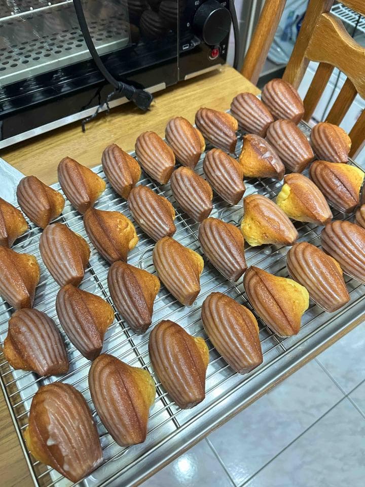 這張照片是一盤美味的瑪德蓮蛋糕。這些蛋糕烤得金黃酥脆,看起來非常誘人。