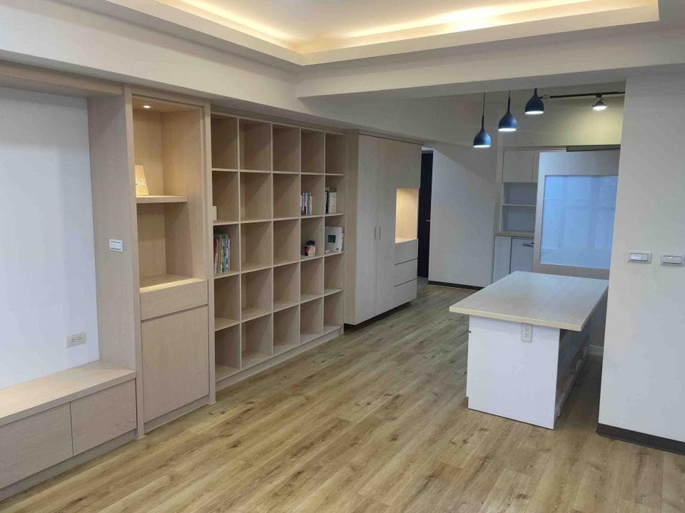 這張照片是一間裝潢精緻的客廳,最引人注目的地方是牆上整面木質的收納櫃,櫃體設計簡潔大方,同時兼具美觀與實用功能。