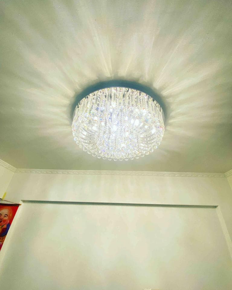 1) 照片顯示一個水晶吊燈,吊在白色天花板中央