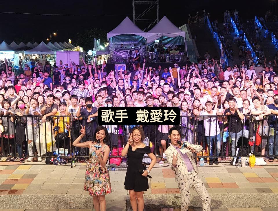 這張照片是演唱會的現場,舞臺前方有很多觀眾,其中最重要的是舞臺上的三位藝人,他們正準備表演。