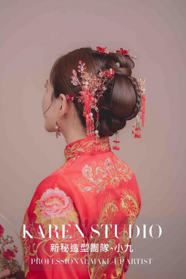 這張照片是一個身穿紅色旗袍的中國新娘,她的頭髮梳著精緻的髮髻,並用傳統的中國頭飾裝飾。