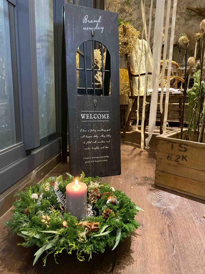 1) 照片中,有一個木製的牌子,上面寫著 "Brand New Day" 和 "Welcome",以及一些裝飾性的字句