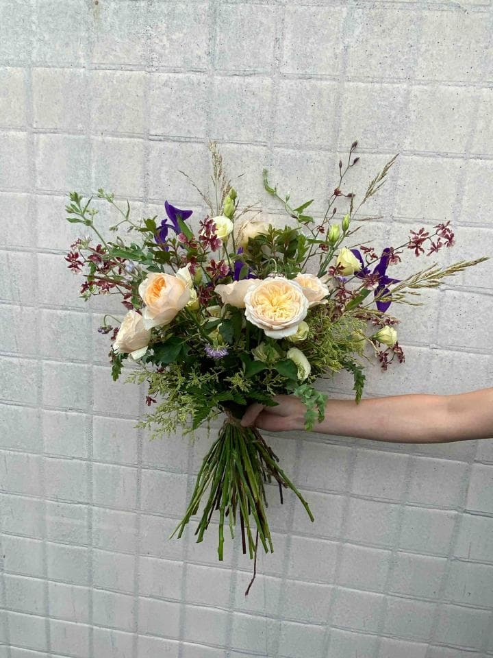 1) 照片展示了一束由各種花朵組成的花束,包括淡黃色的玫瑰、紫色的小花以及綠色的枝葉