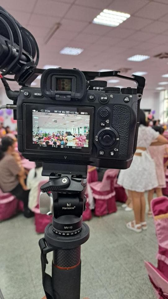 1) 照片顯示一台相機架在三腳架上,前方有模糊的人群