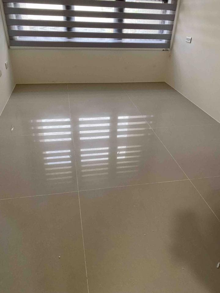 這張照片是一個非常乾淨的房間,地板非常光亮,可以清楚地看到窗戶的倒影。