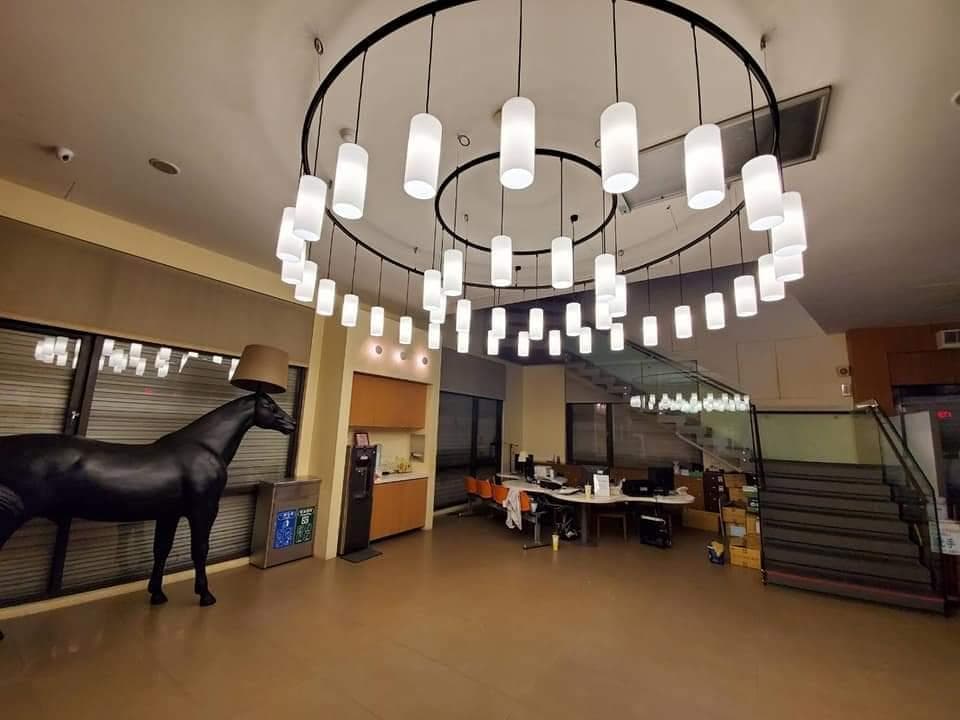 1) 照片顯示一個酒店大廳,大廳中央裝飾著一個大型的吊燈,燈光很明亮,燈罩是白色透明的