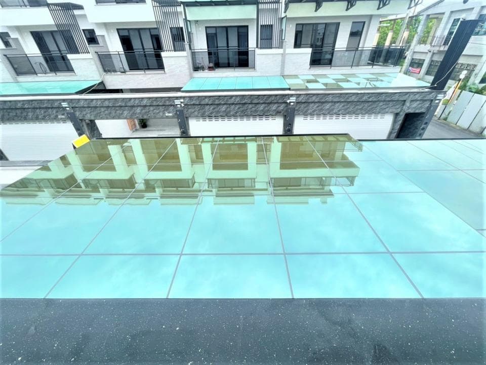 這張「玻璃屋頂」的照片是,玻璃屋頂映照著周圍的建築,呈現出倒影的景色。