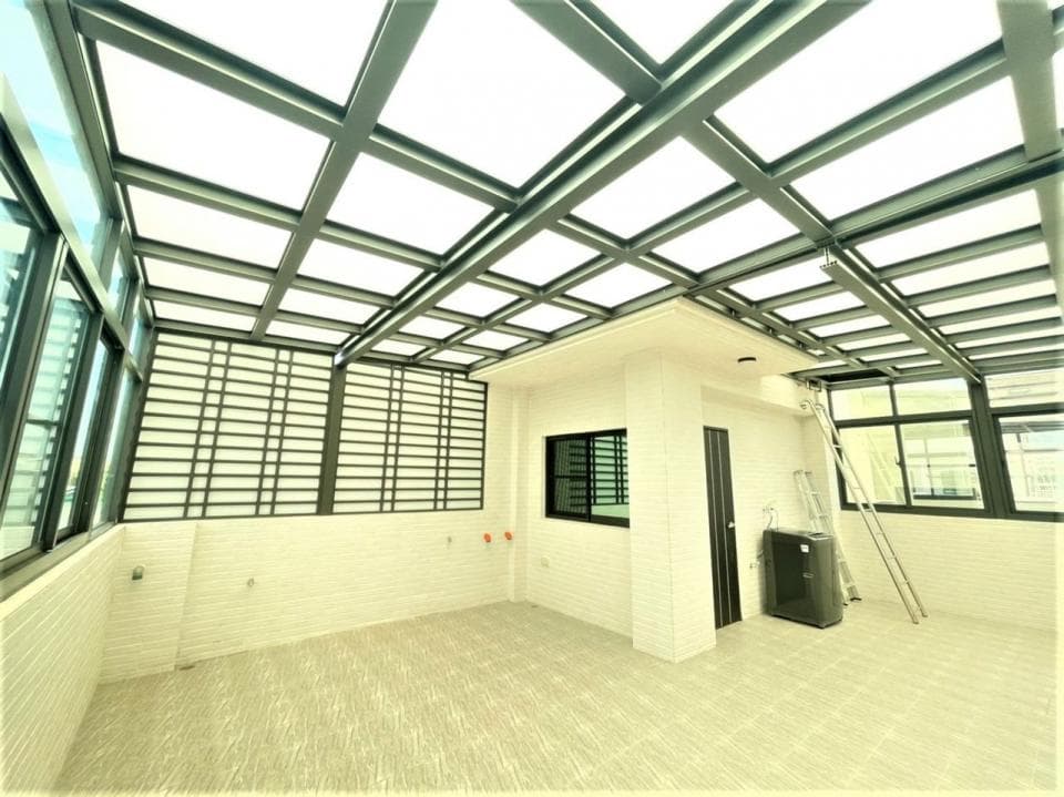 這張「陽臺」的照片是一個開放式的空間,有玻璃屋頂和圍欄,地面鋪著淺色地磚。