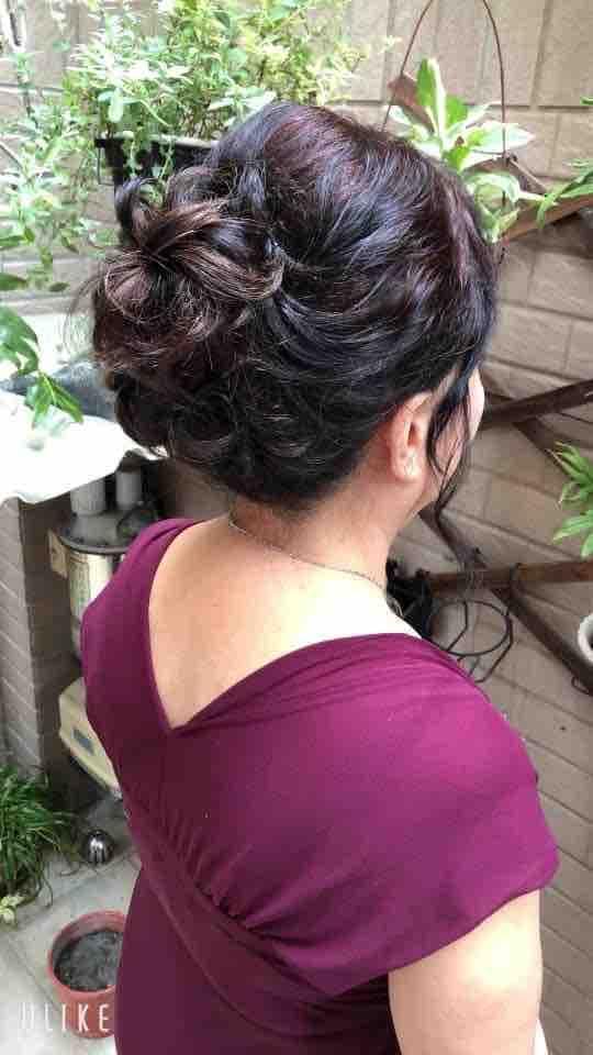 這張「婚禮」的照片是一個穿著酒紅色禮服的女性,她的頭髮梳了一個優雅的髮髻。