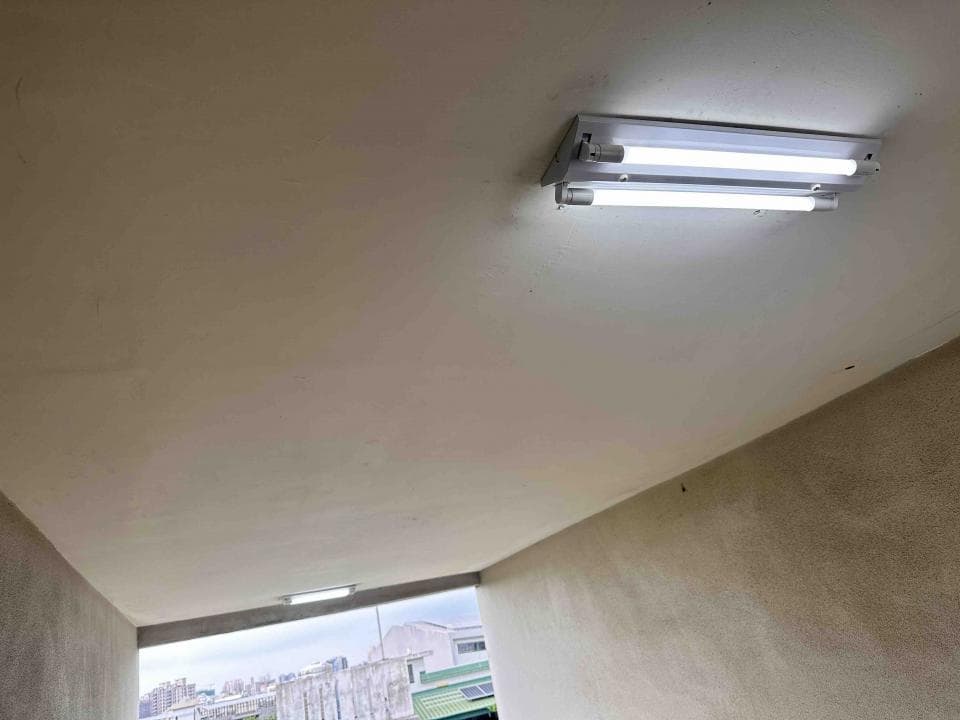 1) 這是一張室內的照片,照片裡有一個房間的角落,天花板上有兩盞日光燈,其中一盞開著,另一盞關著