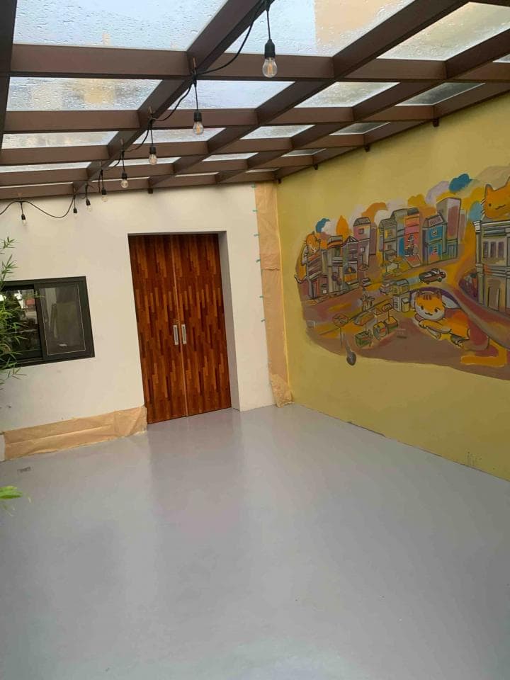 這張「戶外空間」的照片是一個帶有玻璃屋頂的陽臺,陽臺牆壁上繪有壁畫,地板是灰色的。