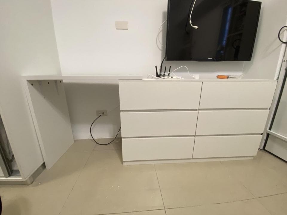 這張照片是一個現代化的房間,房間裏有一張白色書桌,書桌上有四個抽屜。