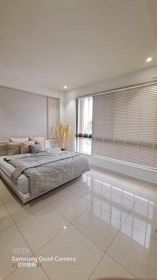 1) 照片顯示一個現代化的臥室,房間裡有一張鋪著灰色床單的床,床邊放著幾個枕頭