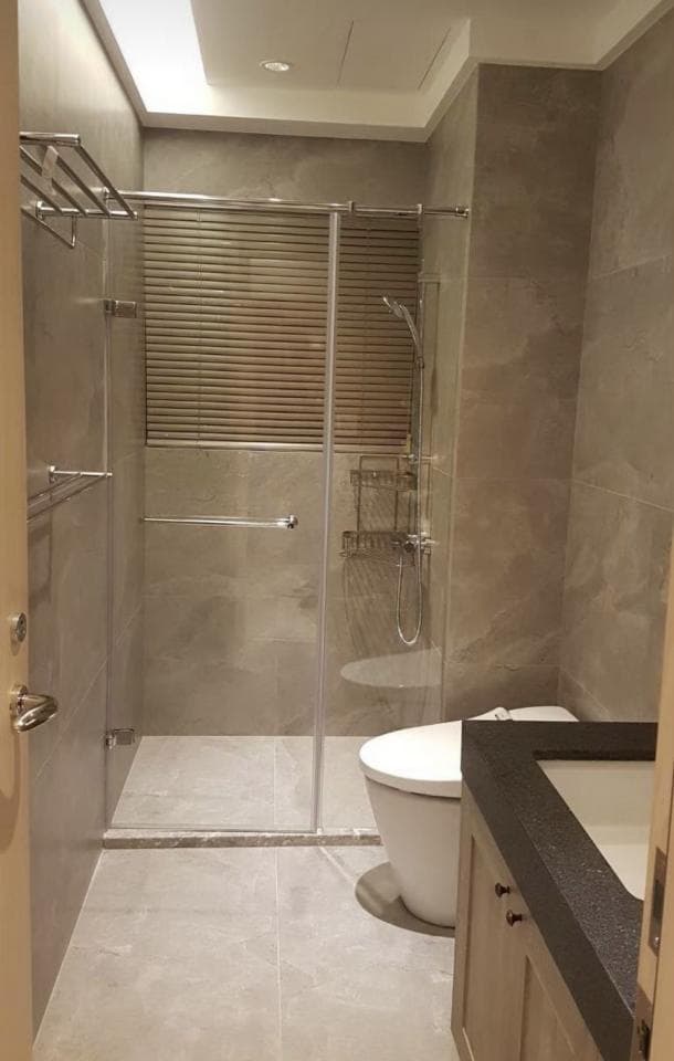 1) 照片顯示一個現代化的浴室,有一個淋浴間、馬桶、洗手台,以及一個木質的梳妝台