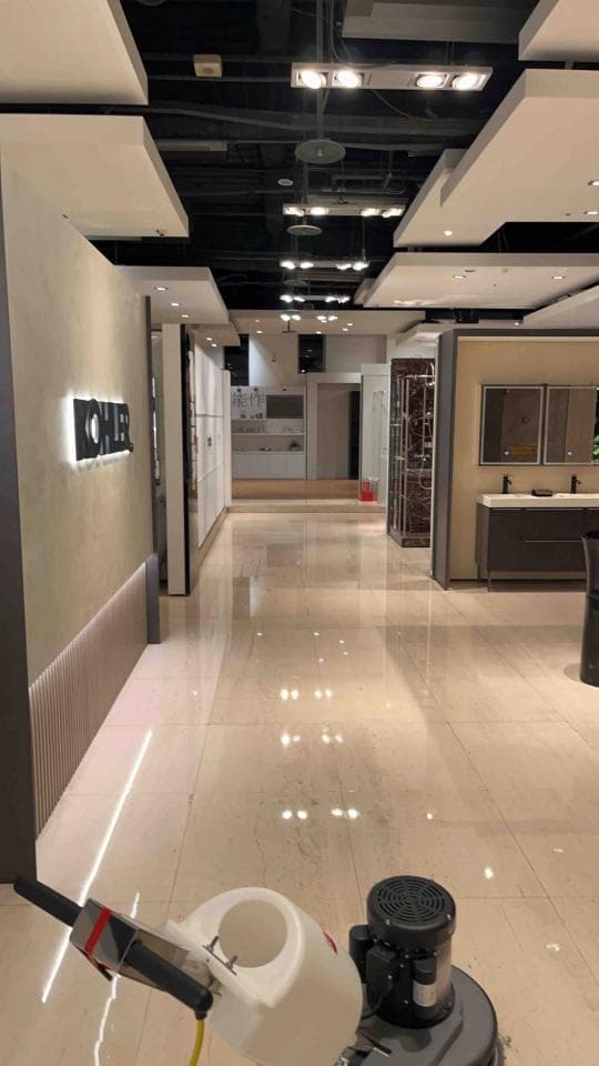 1) 照片顯示一個空蕩蕩的房間,地板上有一台拋光機,房間裡有幾盞燈,地板看起來很乾淨