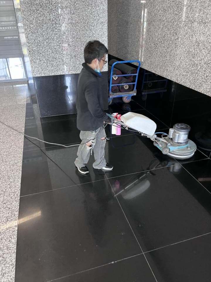 1. 照片顯示一名男子正在使用地板清潔機清潔黑色大理石地板