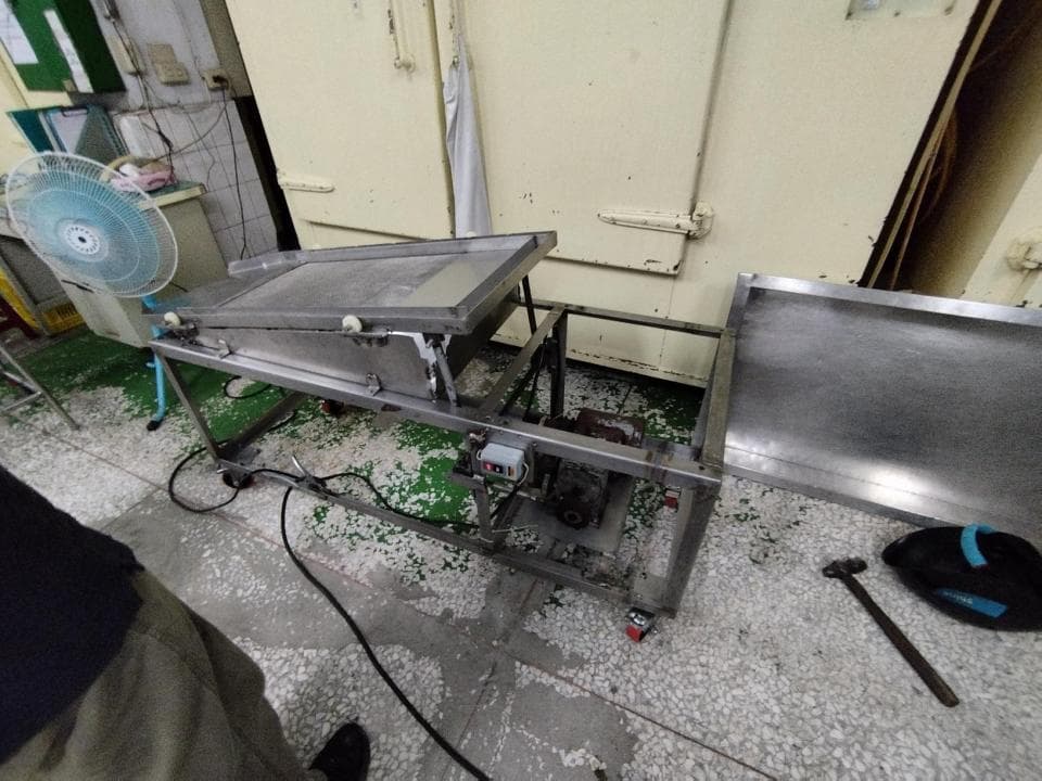 1) 照片顯示一台不銹鋼製的機器,機器上有兩個輸送帶