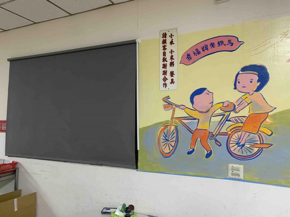 這張「牆上畫著一男一女騎著腳踏車,牆上還有一塊黑板」的照片是。