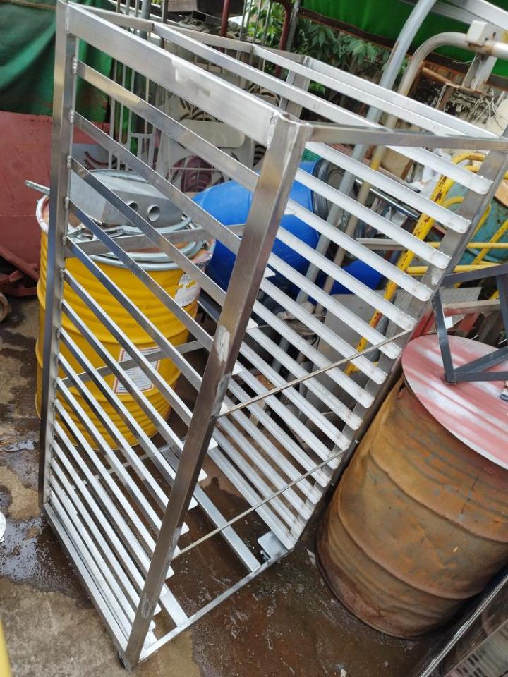 1) 這張照片顯示了一個金屬製的架子,架子上有多層的格子和水平的橫桿,架子旁邊有一個金屬桶