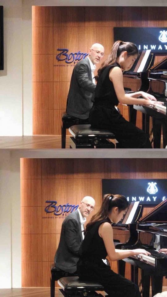 這張照片是兩位女士正在彈奏鋼琴。她們都穿著黑色的衣服,專注地演奏著。鋼琴是黑色的,看起來很高貴,周圍是木質的牆面,整體感覺很優雅。