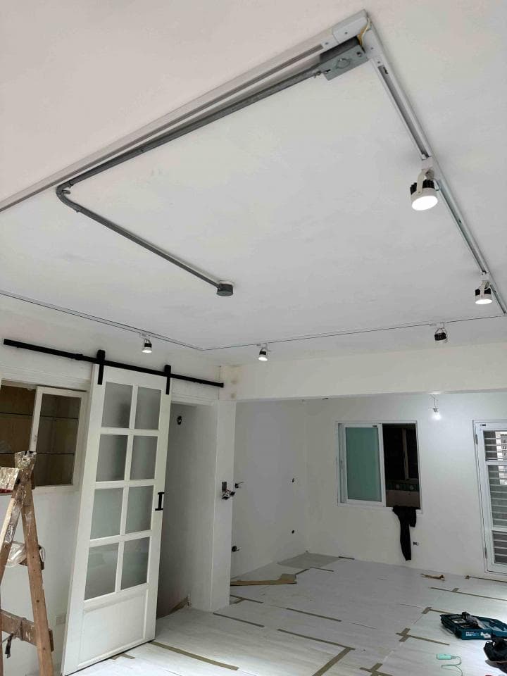 1. 這是一張室內照片,照片中顯示一個白色天花板,裝潢成現代風格的設計,天花板上裝設有軌道燈,並有木門和窗戶