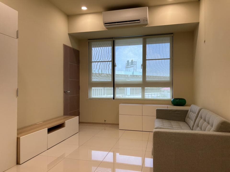 這張照片是一間現代化的客廳,最重要的是沙發,它是一個舒適的淺灰色沙發,配有兩個靠背,並有一個木質茶几。