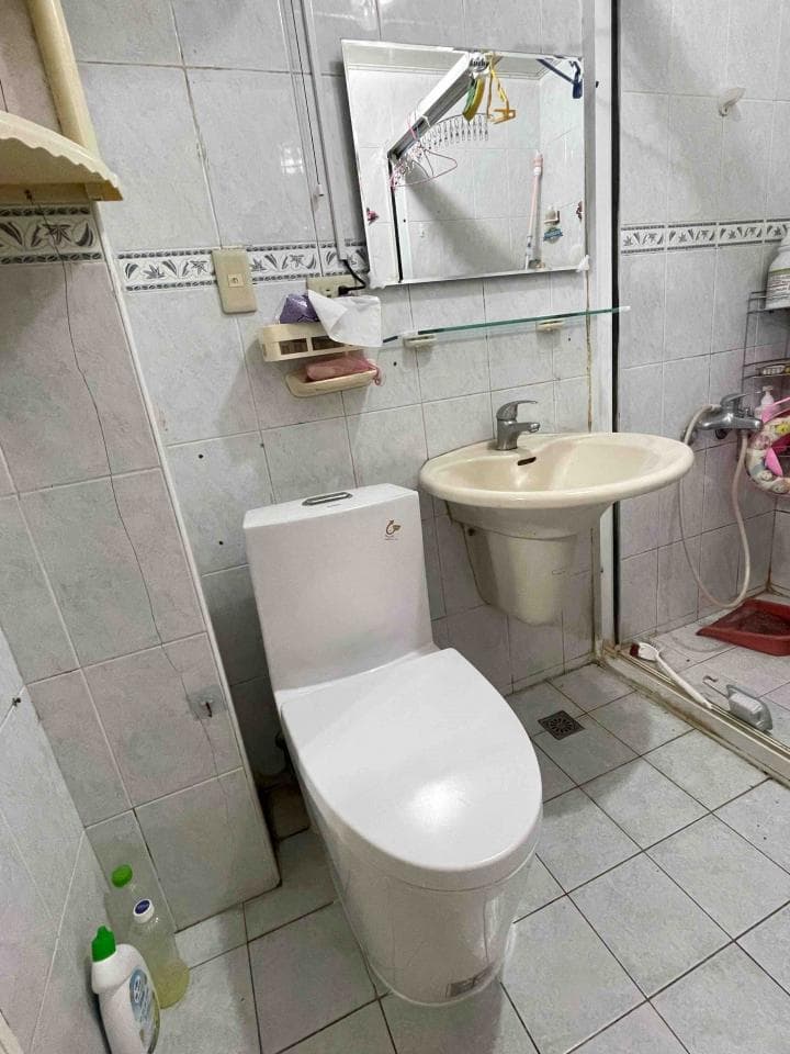 這張照片是一個浴室,裡面有馬桶、洗手台和鏡子。最重要的是馬桶,它看起來很新,表面光滑潔白。