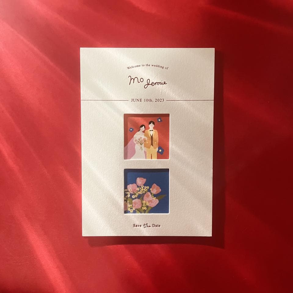 這張照片是一張婚禮喜帖,上面寫著「Mo Jemmie」和「Save the Date」。最重要的是喜帖的右上角,有一張小圖,上面畫著一對新郎新娘,新娘穿著白色的婚紗,新郎穿著紅色的西裝,他們都非常開心。