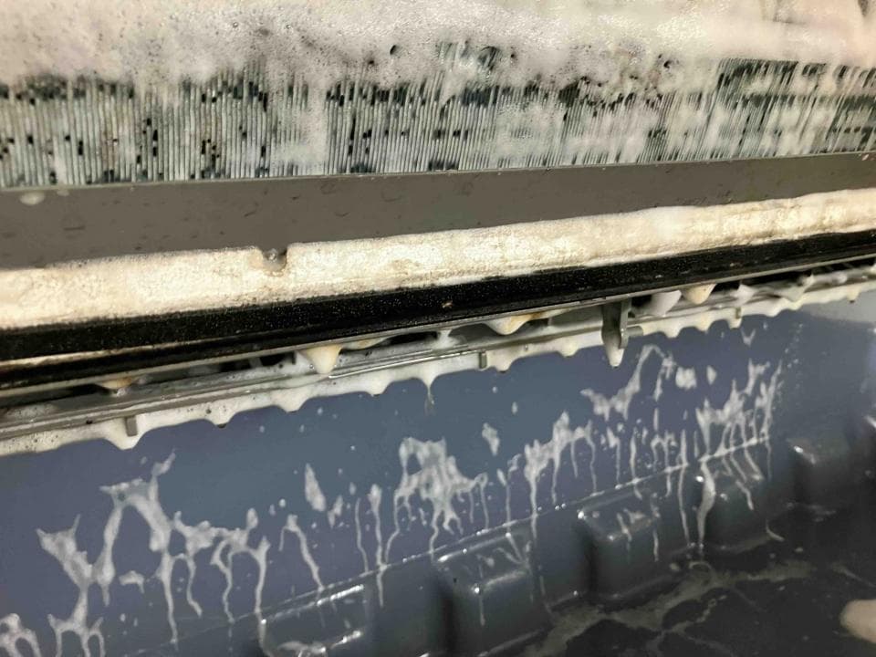 這張照片是一台冷氣機的冷凝器,冷凝器上佈滿了白色泡沫,正在清潔中。