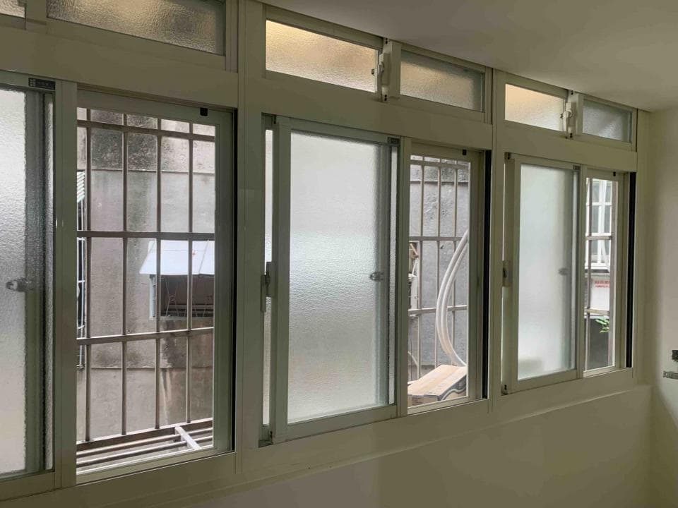 1) 照片顯示一間房間的窗戶,窗戶是白色的鋁框,上面有防盜網,並且採用雙層玻璃,其中一扇窗戶是開著的