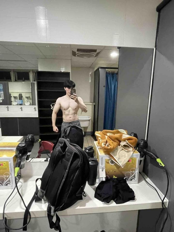 這張照片是一間浴室,最重要的是鏡子裡的那個男人。他看起來很健壯,身材很好,正在照鏡子。