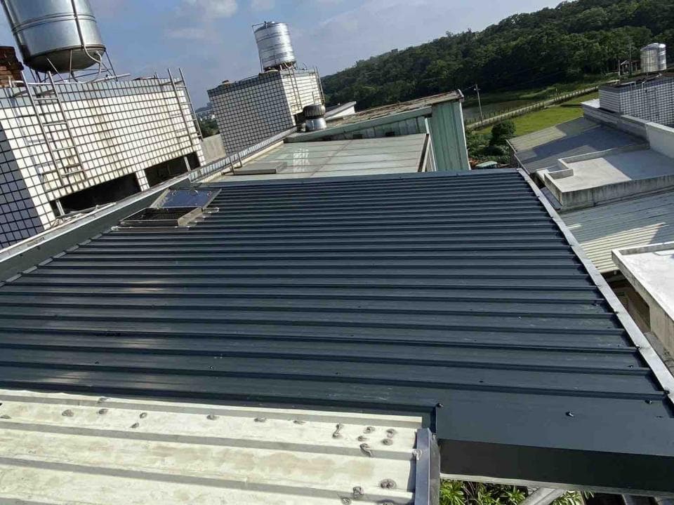 1) 照片顯示一個建築物上的黑色金屬屋頂