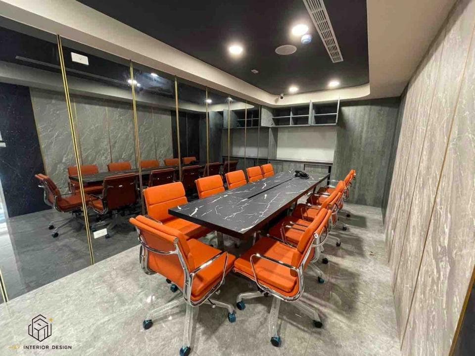 這張「會議室」的照片是一間現代化的會議室,裡面有一張黑色的長桌和多張橙色的椅子,牆壁是灰色的,整體風格簡潔大方。