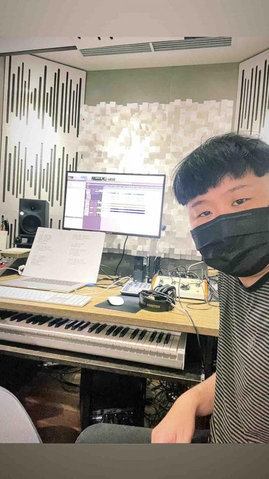 這張「錄音室」的照片是一個戴著口罩的音樂製作人在錄音室裡工作。