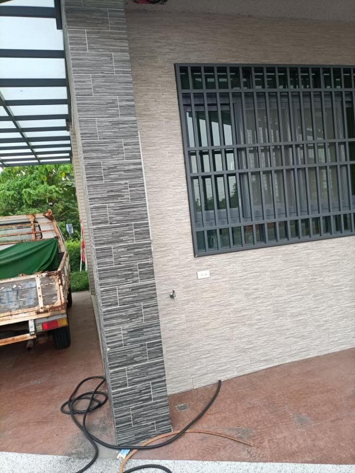 1) 照片顯示一棟房屋的外部,房屋外牆由淺色和深色磚塊構成