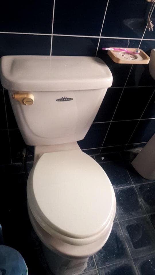 這張照片是一個馬桶。馬桶是白色,上面有一個白色馬桶蓋,馬桶蓋是打開的。