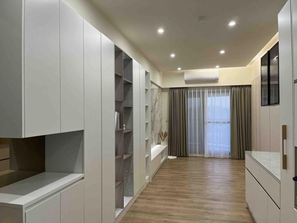 1) 照片顯示一個現代化的客廳,有白色櫥櫃、木地板、窗戶以及一個牆壁上的架子