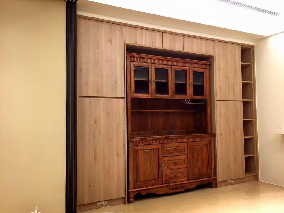 這張照片是一間房間的一角,最重要的是一個木質的櫥櫃,它有玻璃門、抽屜和架子,可以用来存放物品。