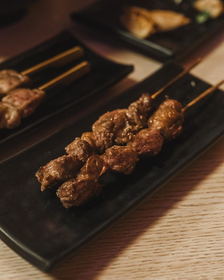 這張照片是一盤烤肉串,上面有幾塊烤肉。肉串是深褐色的,看起來很美味。