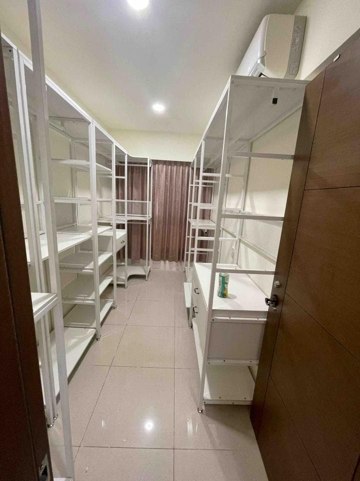 這張照片是一間裝潢精緻的房間,房間裡有一排白色鐵架,架子上整齊地擺放著許多物品,顯得非常有條理。