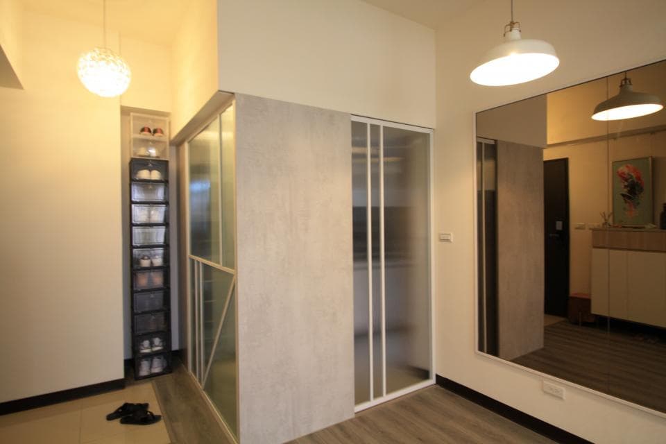 這張「玄關」的照片是一間簡約風格的住宅,以白色和灰色為主色調,並帶有木紋質感,讓空間看起來更溫馨。玄關處設有鞋櫃,方便收納鞋子。