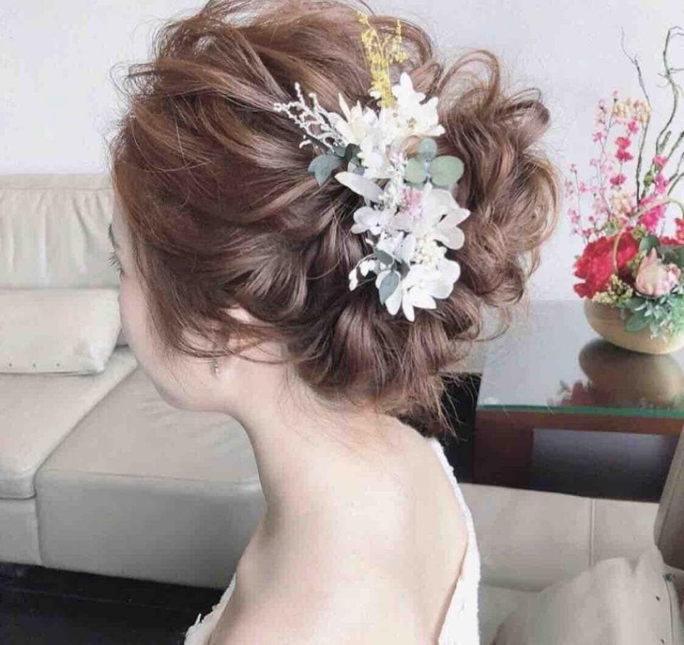 這張「新娘」的照片是一名女子,她留著蓬鬆的棕色長髮,並戴著白色花朵髮飾。