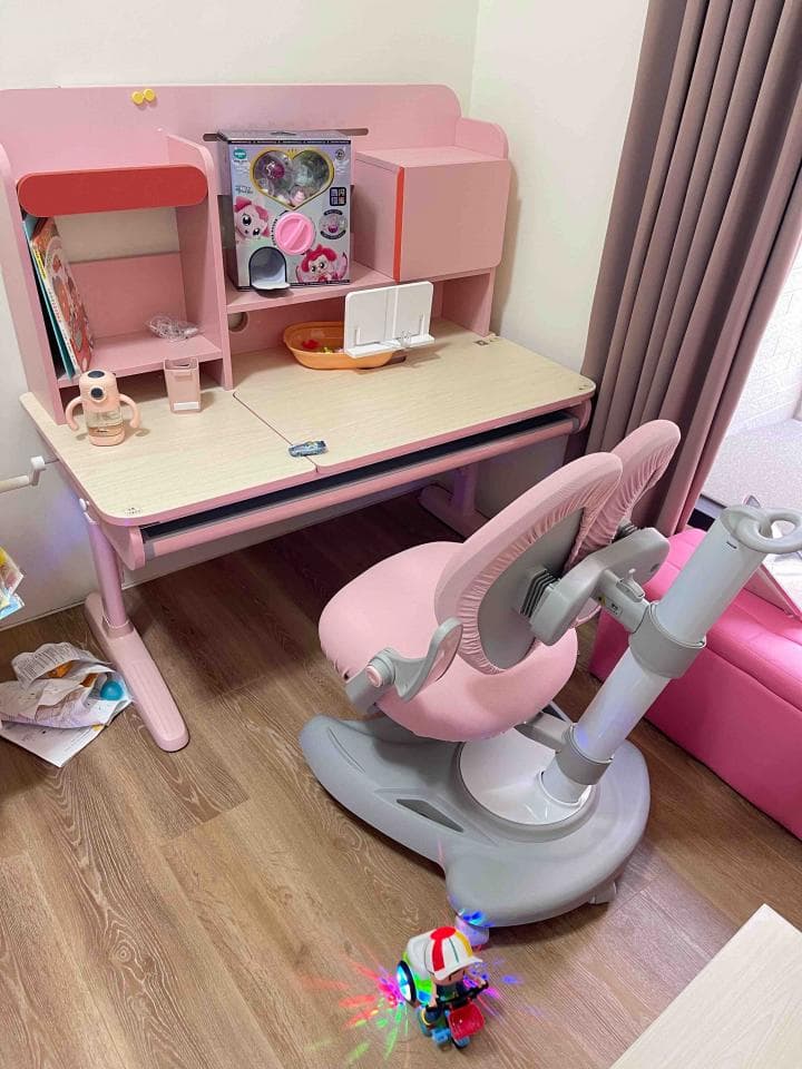 這張照片是一個粉紅色兒童學習桌,配備可旋轉的座椅,方便孩子學習和玩耍。