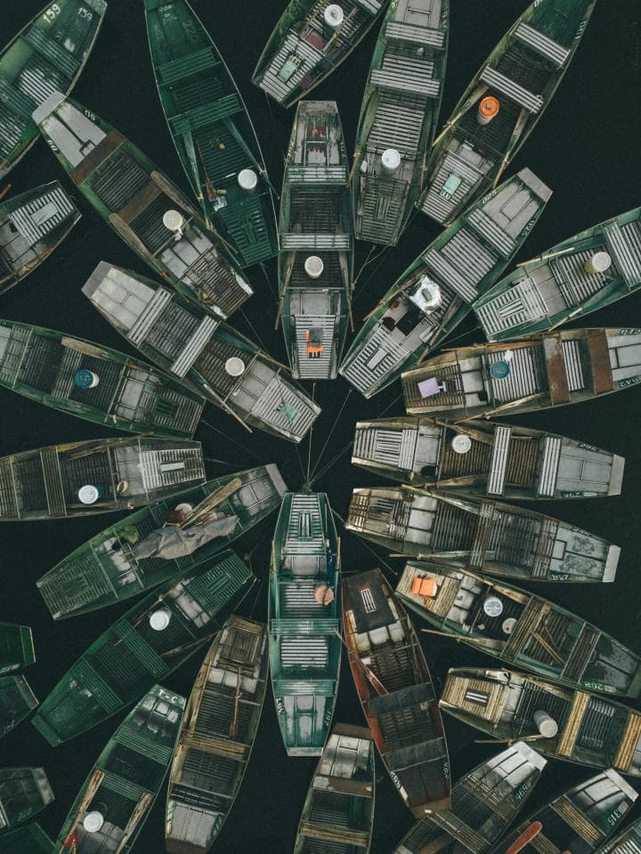 這張「眾多木船」的照片是許多不同大小的木船,它們排列成一個圓形,並朝著中心方向。