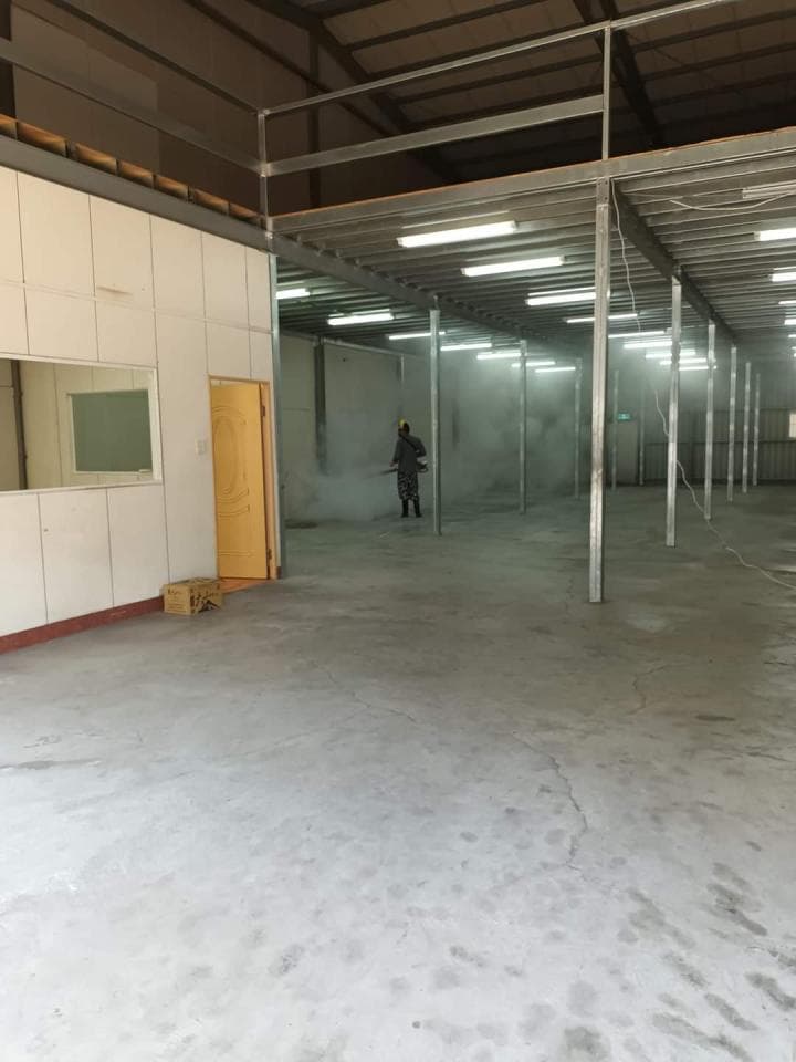 1) 照片顯示一個空蕩蕩的倉庫,裡面有鋼鐵的架子,以及一個戴著安全帽的人