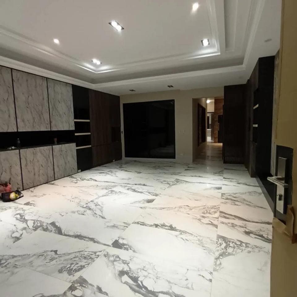 這張照片是一間裝潢精緻的現代化大廳,映入眼簾的是潔白無暇的石材地板,光線明亮,顯得寬敞明亮。