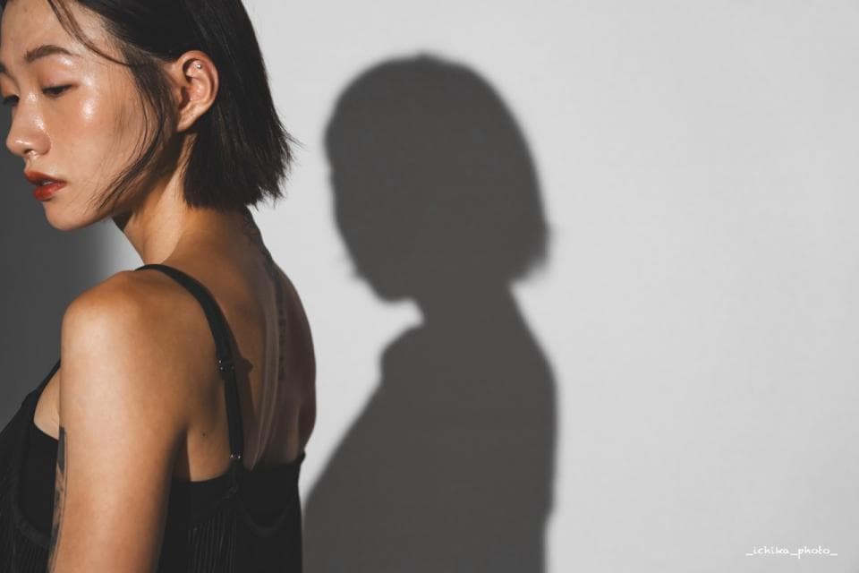 這張「一個女孩站在牆邊,她的影子投射在牆上」的照片是。